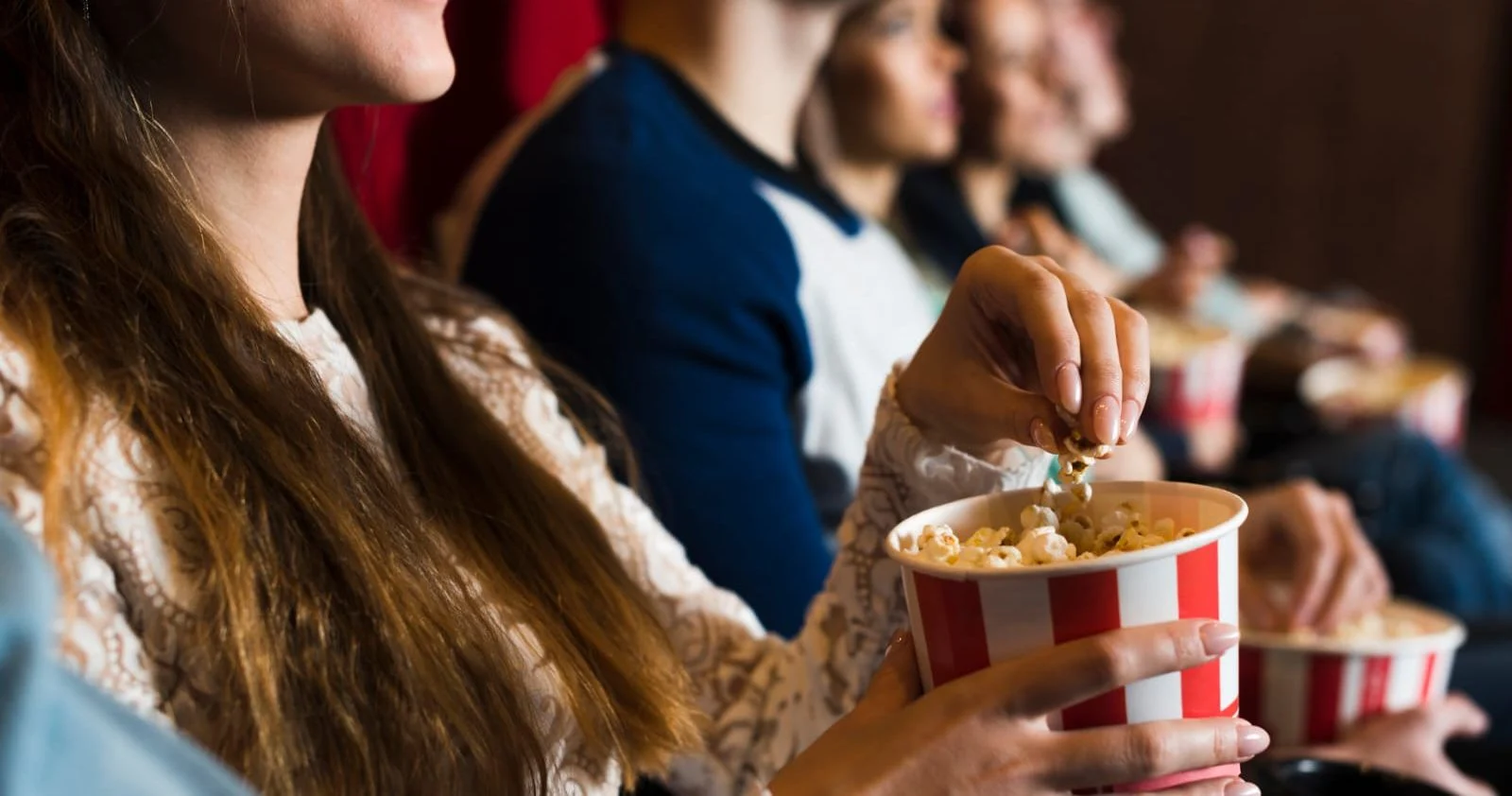 Amigas disfrutando una función de cine con pochoclos